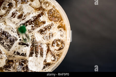 Blick von oben auf Eis Kaffee in einem plasstic Glas mit Strohhalm Stockfoto