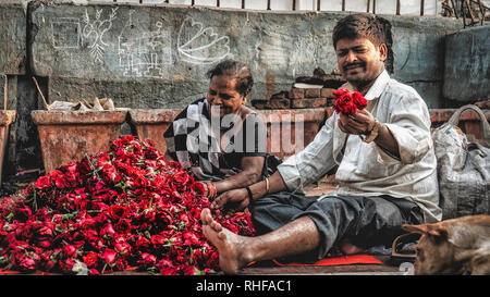 Ein Paar, das in den Straßen von Bombay mit vielen Rosen Stockfoto