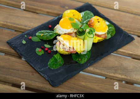 Mini Burger mit Kartoffeln, Speck, Wachteleier und Grüns Stockfoto