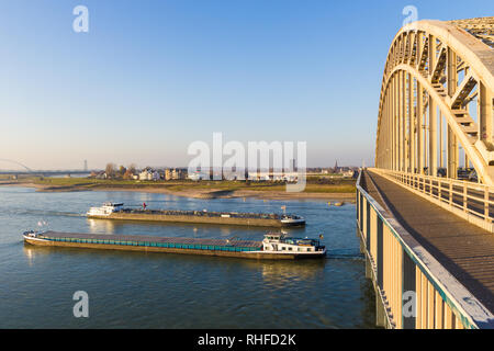 Nijmegen, Niederlande - 16 November 2018: cargo Binnenschiffe vorbei unter Waal Brücke in Nimwegen während der Zeit des niedrig Stockfoto