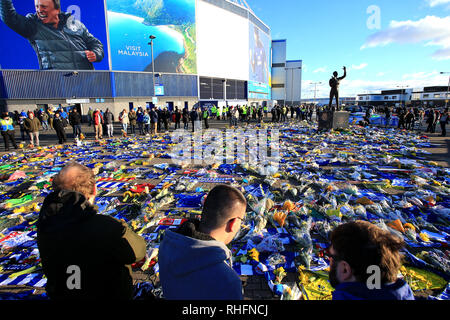 Fans schauen auf die Blumen und Schals außerhalb Cardiff City Stadium in Hommage an Emiliano Sala platziert in der Premier League Match in Cardiff City Stadium. Stockfoto