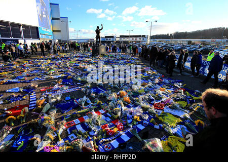 Fans schauen auf die Blumen und Schals außerhalb Cardiff City Stadium in Hommage an Emiliano Sala platziert in der Premier League Match in Cardiff City Stadium. Stockfoto