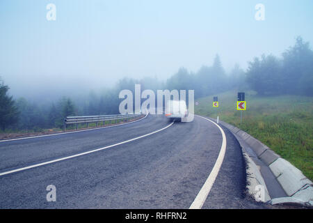 Alpine zweispurigen Straße cvered im dichten Nebel Stockfoto