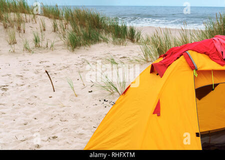 Zelt und Feuer am Strand, gelbe Zelt auf dem Sand Stockfoto