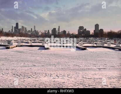 Geräumt Boat Harbour für Winter- und Frozen Lake Michigan im Schnee während des Polarwirbels und Blick auf die Skyline von Downtown Chicago. Stockfoto