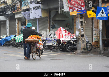 Hanoi, Vietnam - 13. Dezember 2017. Eine Straße Verkäufer verkauft Äpfel und Orangen von seinem Fahrrad in der historischen Altstadt von Hanoi Stockfoto