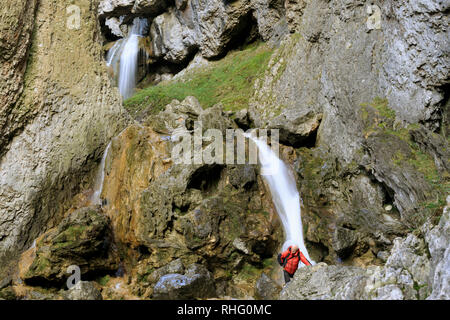 Ein Bergsteiger Pausen, als er seinen Weg macht den Wasserfall in Gordale Scar, Yorkshire Dales Stockfoto