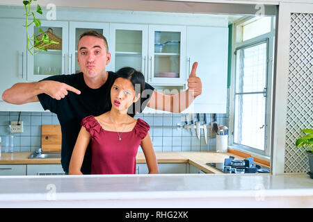 Paar schöne Posing - Mann zeigt Ihre junge Frau und Daumen nach oben Geste Stockfoto