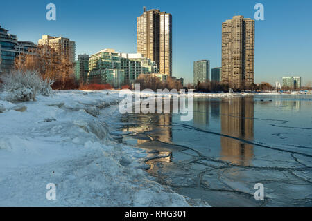 Panoramablick auf die kanadischen Winter Landschaft in der Nähe von Toronto, schöne gefrorene Ontario See bei Sonnenuntergang. Landschaft mit Winter Bäume, Wasser und blauer Himmel. Stockfoto