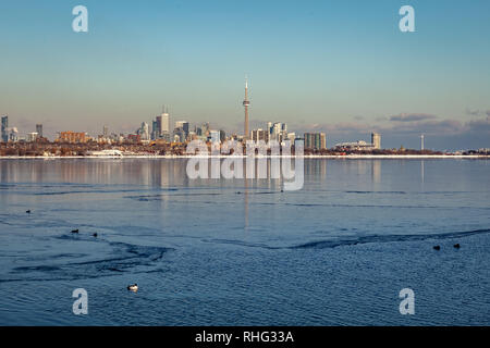 Panoramablick auf die kanadischen Winter Landschaft in der Nähe von Toronto, schöne gefrorene Ontario See bei Sonnenuntergang. Landschaft mit Winter Bäume, Wasser und blauer Himmel. Stockfoto