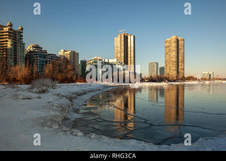 Panoramablick auf die kanadischen Winter Landschaft in der Nähe von Toronto, schöne gefrorene Ontario See bei Sonnenuntergang. Landschaft mit Winter Bäume, Wasser und blauer Himmel. Stockfoto