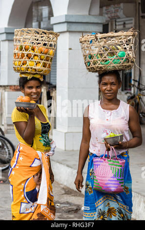 Toliara, Madagaskar - Januar 10th, 2019: Zwei lokale madagassische Frau mit Korb auf dem Kopf Verkauf von Obst in den Straßen auf dem Markt von Toliara, Stockfoto