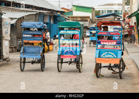 Toliara, Madagaskar - Januar 10th, 2019: Ansicht der Rückseite drei Zyklus pousse pousse im kommerziellen Zentrum von Toliara, Madagaskar. Stockfoto