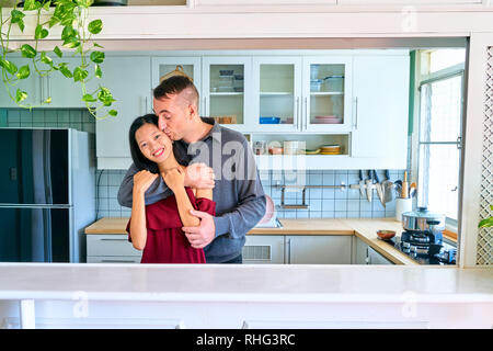 Paar schöne Posing-Wange küssen und umarmen Stockfoto