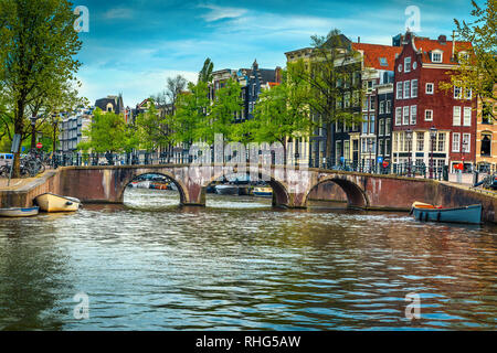 Fantastische reisen und touristische Destination, spektakuläre Stadtbild mit traditionellen niederländischen Häusern. Wasser Kanal mit Booten und die Brücke über den Fluss, die Ams Stockfoto