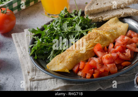 Perfekte Eier, Omelett mit Salat, frische Rucola und Saft Stockfoto