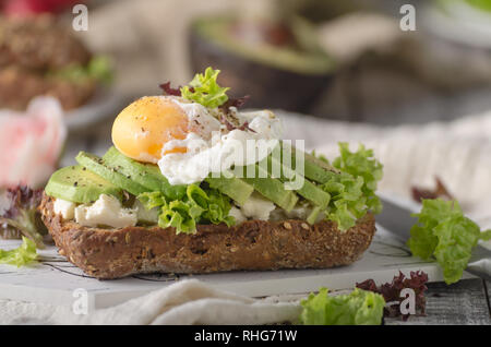 Hausgemachte avocado pochiertes Ei sandwich Vollkornbrot, Essen Fotografie Stockfoto