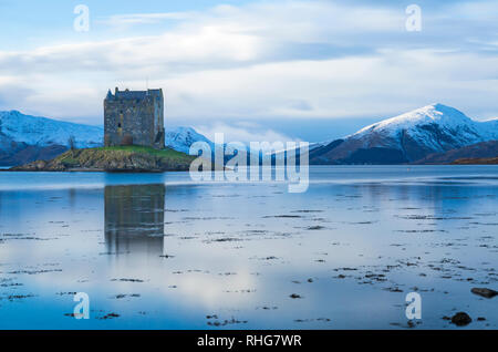 Stalker schloss mit Reflexion auf Loch Laich, ein Eingang aus Loch Linnhe bei Dämmerung, Highlands, Schottland mit Schnee bedeckte Berge, Winter - lange Belichtung Stockfoto