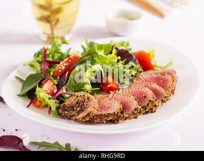Traditionelle japanische Salat mit Stücken von medium-Rare gegrillten Ahi-Thunfisch und Sesam mit frischem Gemüse Salat auf einen Teller. Authentische japanische Küche. Stockfoto