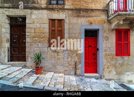 Vorderansicht des Hauses aus Stein mit typischen bunten Holztüren in Valletta, Malta. Stockfoto
