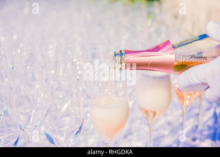Kellner gießen Champagner, Sekt in Gläser im freien Empfang, tragen weiße Handschuhe, schäumenden Wein im Glas, niemand, Copyspace Stockfoto