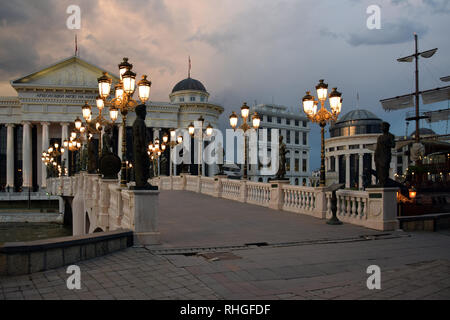 Skopje, Mazedonien - Mai 2017: Die Brücke von Zivilisationen mit Archäologischen Museum von Mazedonien Fassade bei Nacht. Skopje, Mazedonien. Stockfoto