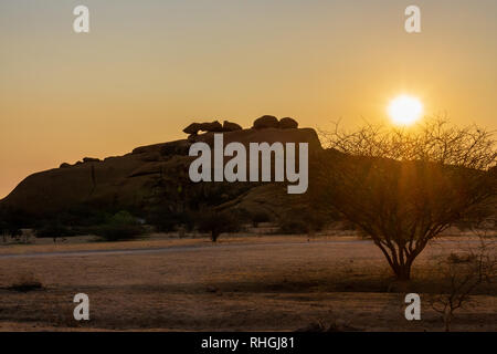 Alten Granitfelsen bilden einen natürlichen Bogen in der Wüste Namib, in der Dämmerung. In Spitzkoppe Namibia. roadtrip Stockfoto