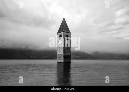 Die Spitze der alten Kirchturm von Graun im Vinschgau - Italien - ergibt sich aus dem Wasser Stockfoto