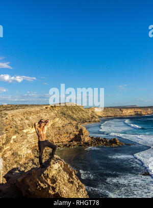 Jung Mann stand auf Felsen in der Nähe von port lincon bei Sonnenuntergang, South Australia, Australien Stockfoto