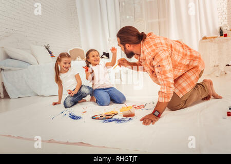 Netter Mann, die eine Malerei Pinsel begeistert Stockfoto