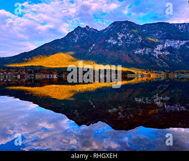 Landschaftlich schöne Sonnenuntergang an der Österreichischen Alpen. Alte vintage ländliche Häuser und Holz- Boot Häuser in Alpen Hallstatt Mountain Lake an der blauen Stunde. Locati Stockfoto