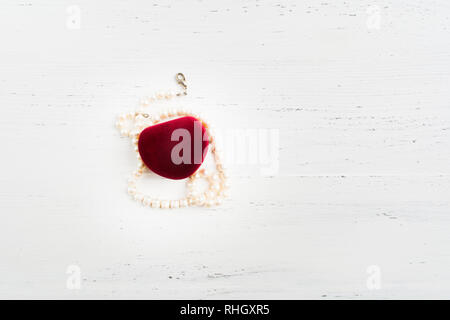 Geschlossene Box für Schmuck mit Perlen Halskette auf weissem Holztisch mit Kopie Raum, flach Stockfoto