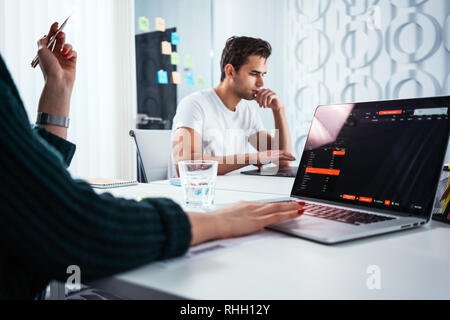 Сolleagues Analysieren digital berichtet auf dem Bildschirm überwachen und Erstellung der finanziellen Report für Investoren. Team von Business Manager bei Mann und Frau sitzen Stockfoto