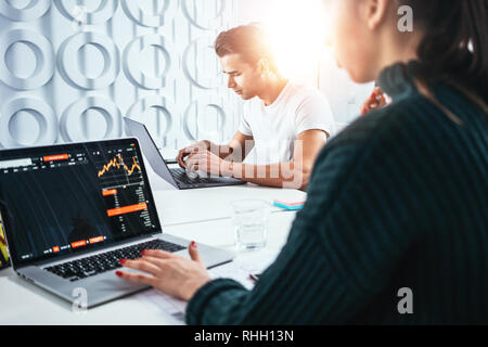 Сolleagues Analysieren digital berichtet auf dem Bildschirm überwachen und Erstellung der finanziellen Report für Investoren. Team von Business Manager bei Mann und Frau sitzen Stockfoto