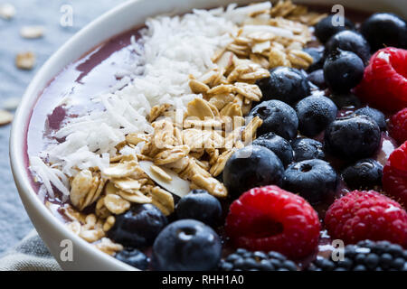 Nahaufnahme von acai Beeren und Müsli in Joghurt Schüssel. Stockfoto