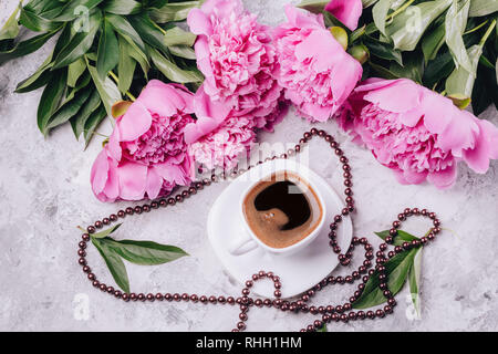Kaffee auf dem Tisch in eine Schale mit Blumen Pfingstrosen Stockfoto