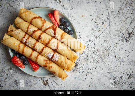 Teller köstliche Crepes Rolle mit frischem Obst und Schokolade Stockfoto