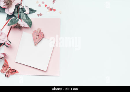 Grußkarte mock up mit Pastell rosa Herzen und Blumen auf weißem Hintergrund, Ansicht von oben, Grenze. Flach. Kann mit zu Muttertag, Hochzeit, Geburtstag Stockfoto