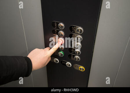 Hand, drücken Sie die ALARM-Taste, um in den Fahrstuhl. Stockfoto