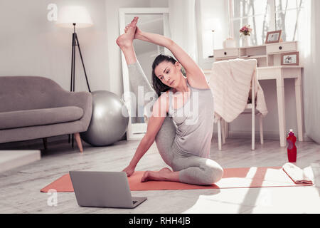 Frau Üben Yoga, die während der Arbeit mit dem Computer