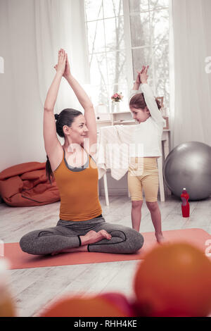 Die Mutter ihrer kleinen Tochter Yoga Posen Stockfoto