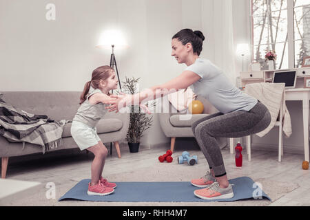 Die Mutter ihrer Tochter zu tun, Sit-ups Stockfoto