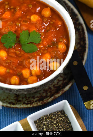 Hausgemachte vegetarische warme Winter Suppe mit Tomaten, Kichererbsen und Linsen von oben schließen oben mit Kopie Raum im Hintergrund Schuß Stockfoto