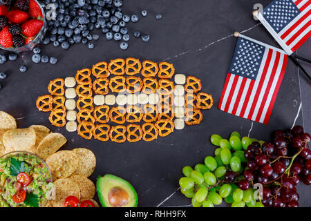 Bier, Snacks und Rugby Ball mit Chips und Salsa auf Holztisch. Fußball fan party Konzept. Stockfoto
