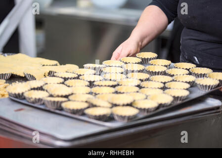 Konditor Törtchen, setzen Sie den Teig in Backformen, in der Küche der Konditorei. Stockfoto