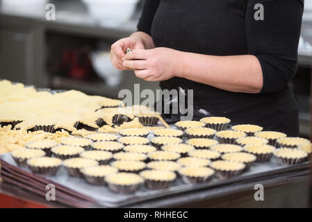 Konditor Törtchen, setzen Sie den Teig in Backformen, in der Küche der Konditorei. Stockfoto