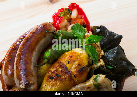 Bulgarische Küche. Kapama - Gemischte geschmorte Platte aus Fleisch, Wurst, Kohlrouladen, Weinblätter und Paprika Stockfoto