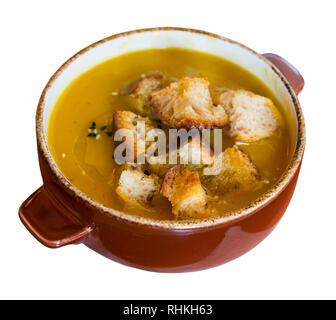 Köstliche pürierte vegetarische Suppe serviert mit knusprigen Croutons in Ton Terrine. Auf weissem Hintergrund Stockfoto