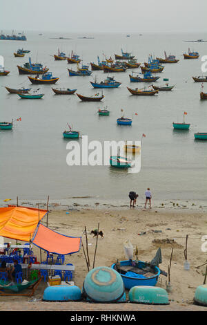 Mui Ne, Vietnam - 27. Dezember 2017. Passanten Blick auf die Fischerboote außerhalb ein Restaurant im Freien in Mui Ne Fischerdorf Stockfoto