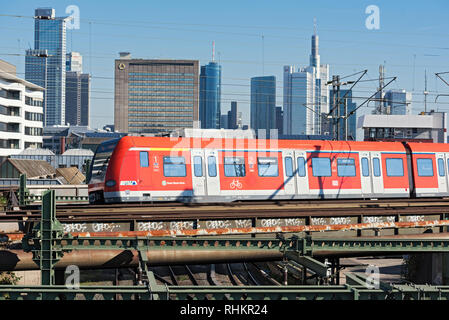 Eine rote Regionalbahn rhein-main Verkehr vor der Skyline, Frankfurt am Main, Deutschland Stockfoto